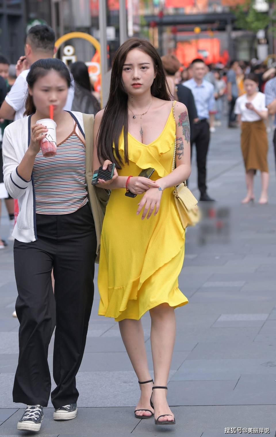 美女街拍:花臂小姐姐穿上黄色的吊带低胸裙,露出迷人的事业线!