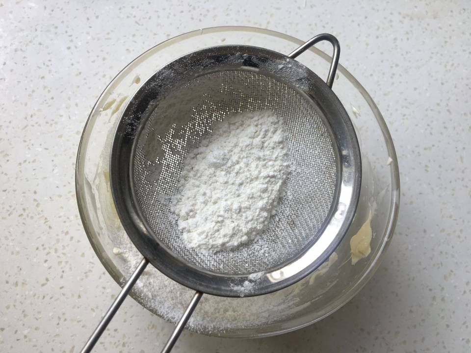 加入一百八十克低筋面粉,戴上一次性手套,用手充分抓匀面粉和黄油融合