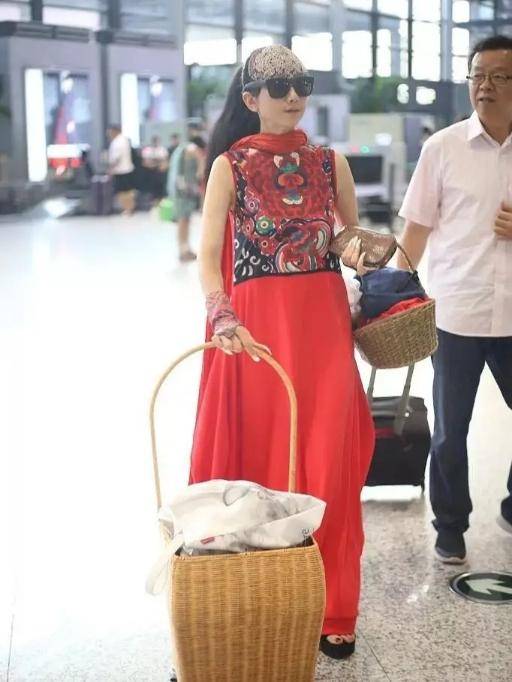 竹筐|60多岁的杨丽萍活出了自信，穿红色民族裙走机场，手推竹筐好洋气
