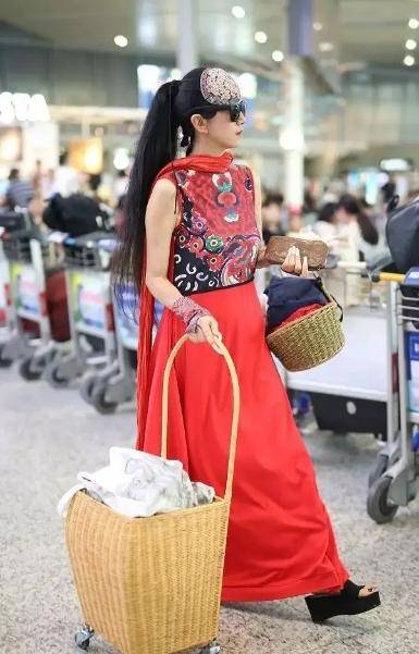 竹筐|60多岁的杨丽萍活出了自信，穿红色民族裙走机场，手推竹筐好洋气