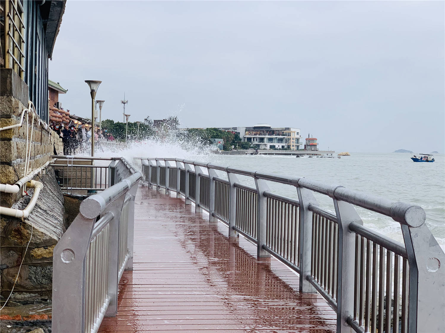 厦门版"小钱塘江,海浪拍打木栈道,游客冒着淋湿来回跑