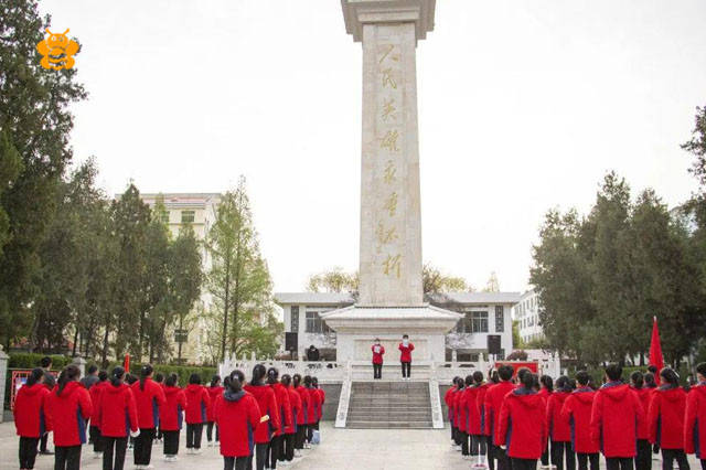 伴着飘扬的队旗,师生们排着整齐的队伍步行前往烈士陵园