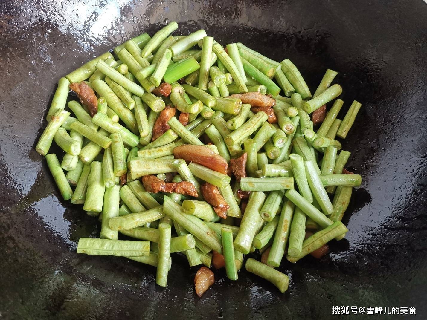 第四步:倒入长豆角煸炒均匀,倒入少许清水,大火烧开,改成小火慢慢炖