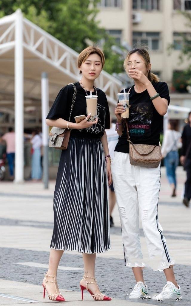 路人街拍女子穿白色的超短紧身裤显露出迷人的筷子腿真养眼泛亚电竞(图1)