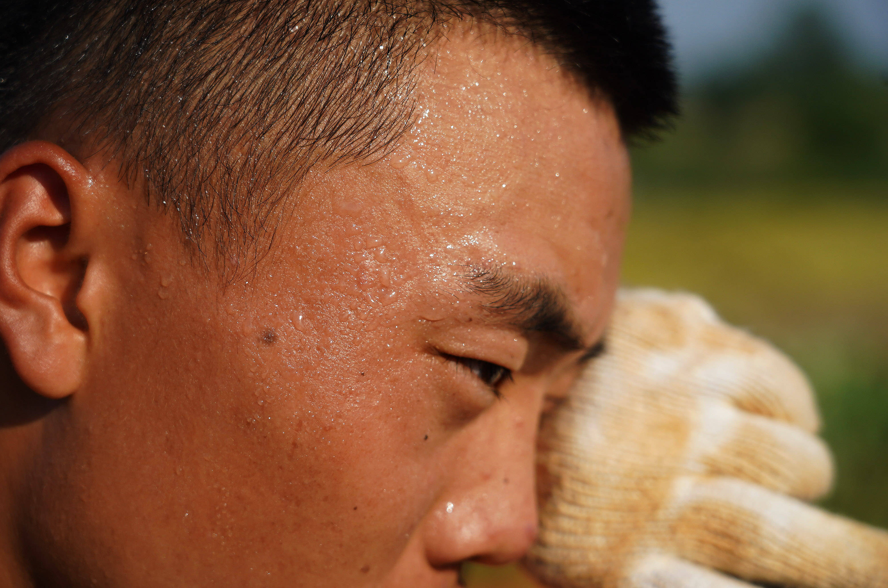 武警江西总队上饶支队的一名战士在擦拭脸上的汗水(7月14日摄).