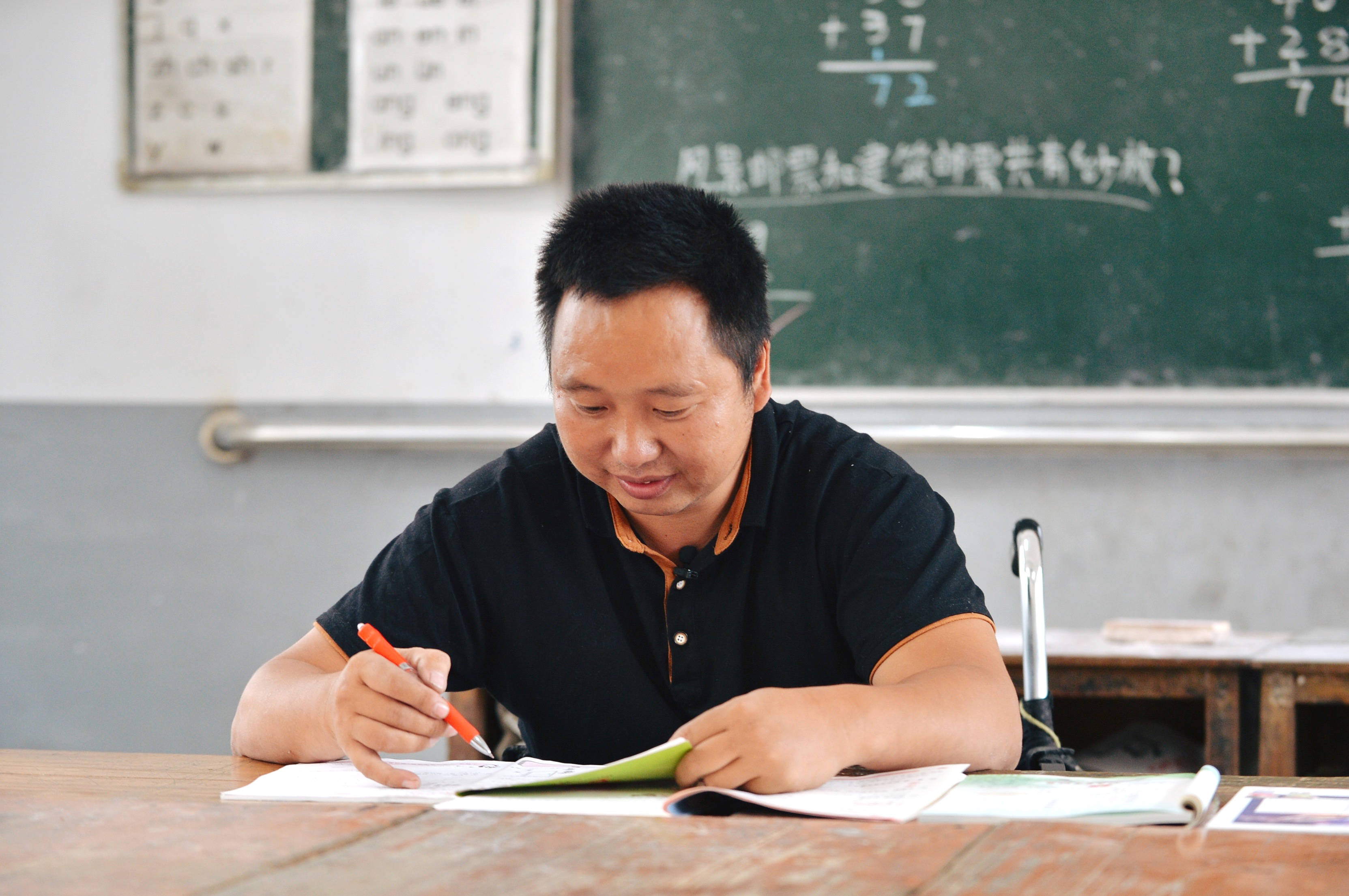 在念恩小学,阮文凭在批改作业(9月8日摄.