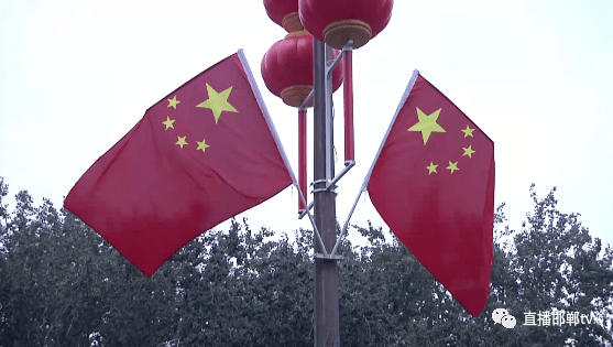 挂国旗迎国庆 古城街头洋溢"中国红"