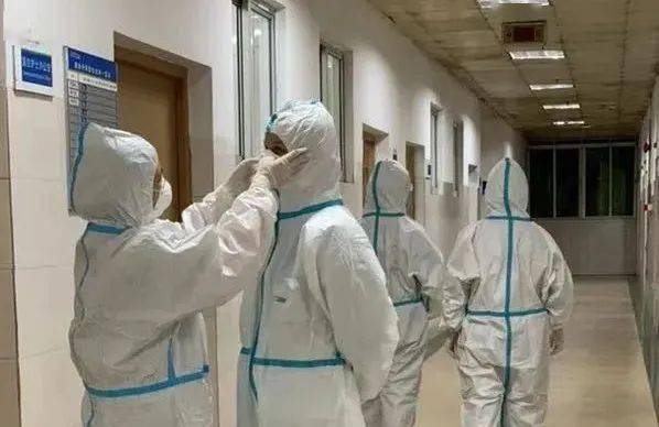 医护人员相互检查防护服的穿戴(资料图)