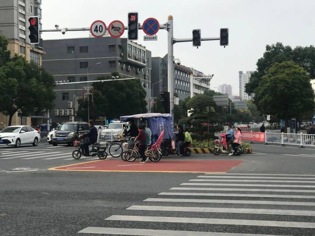 醒目的红色待转区上面画有白色的非机动车图案,以及白色的左转引导线