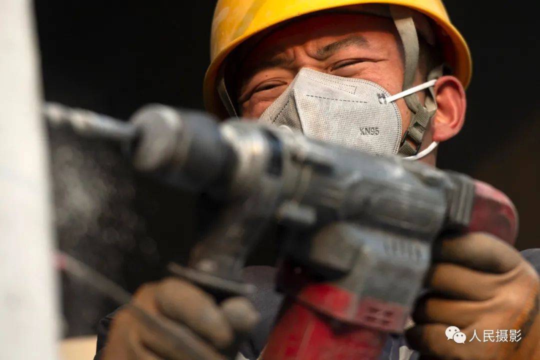 2020年12月6日,一名电钻工人戴着kn95口罩作业.