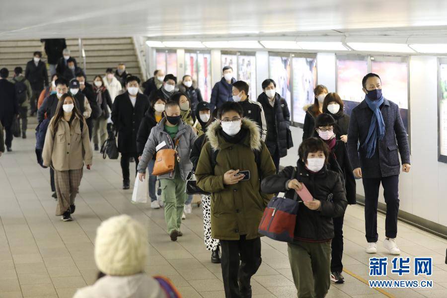 1月22日,在日本东京新宿车站,人们戴口罩出行.