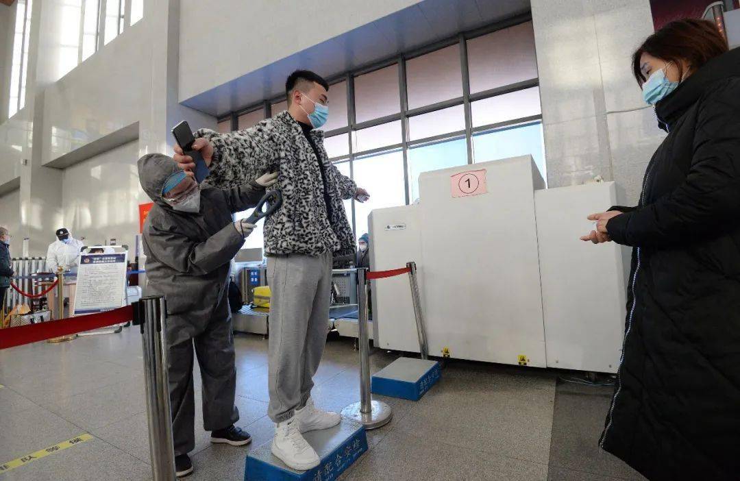 1月28日,邯郸火车站安检人员对出行旅客进行安检.