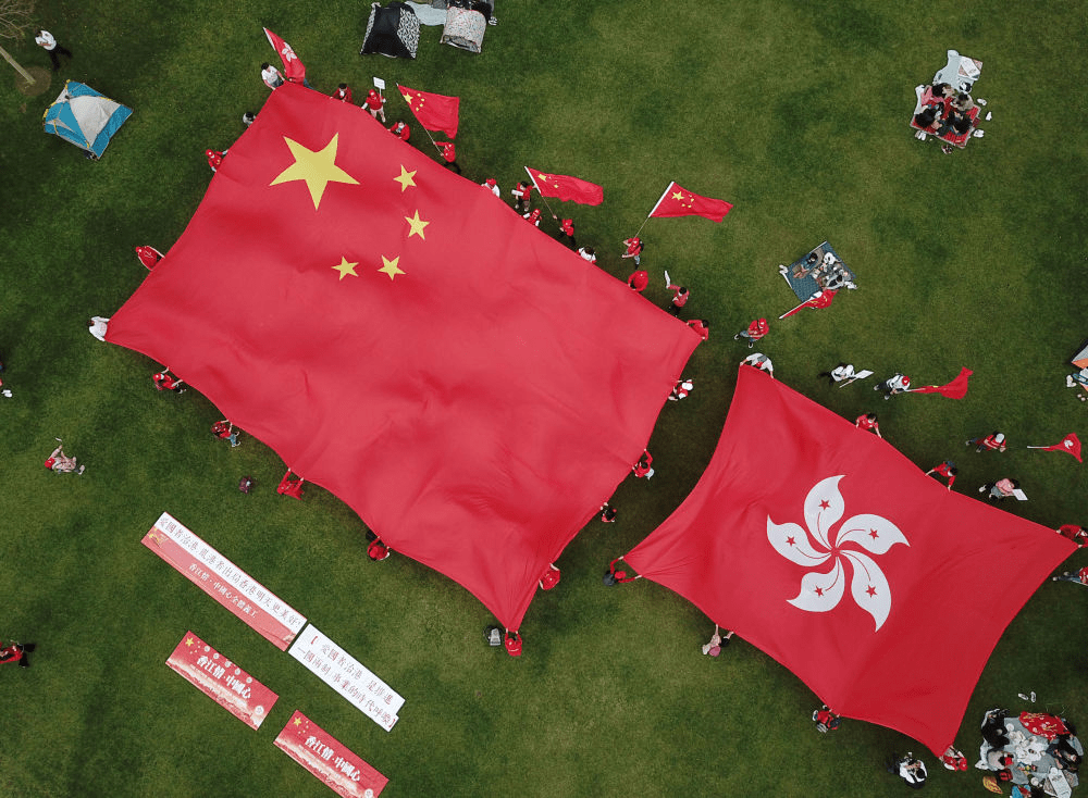 在香港添马公园,香港市民展示五星红旗和香港特区区旗,支持落实"爱国