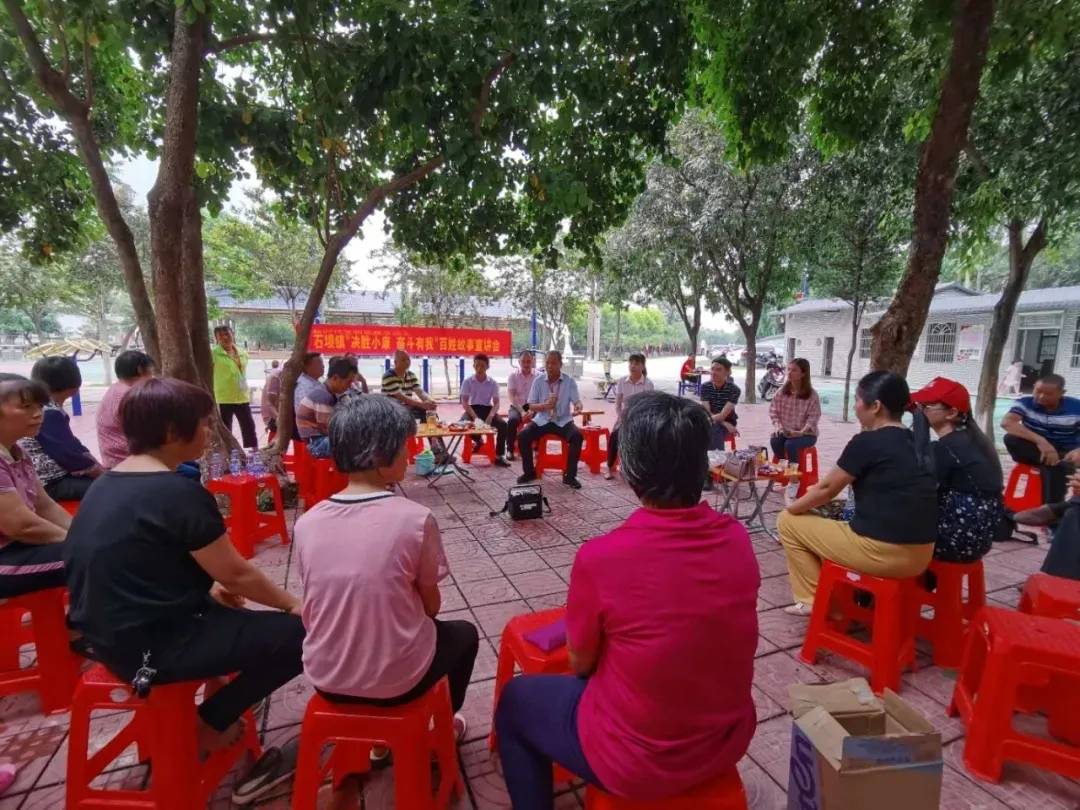 广场边,大树下,石坝镇三嘉村村民在听身边人"唠嗑"家国事.