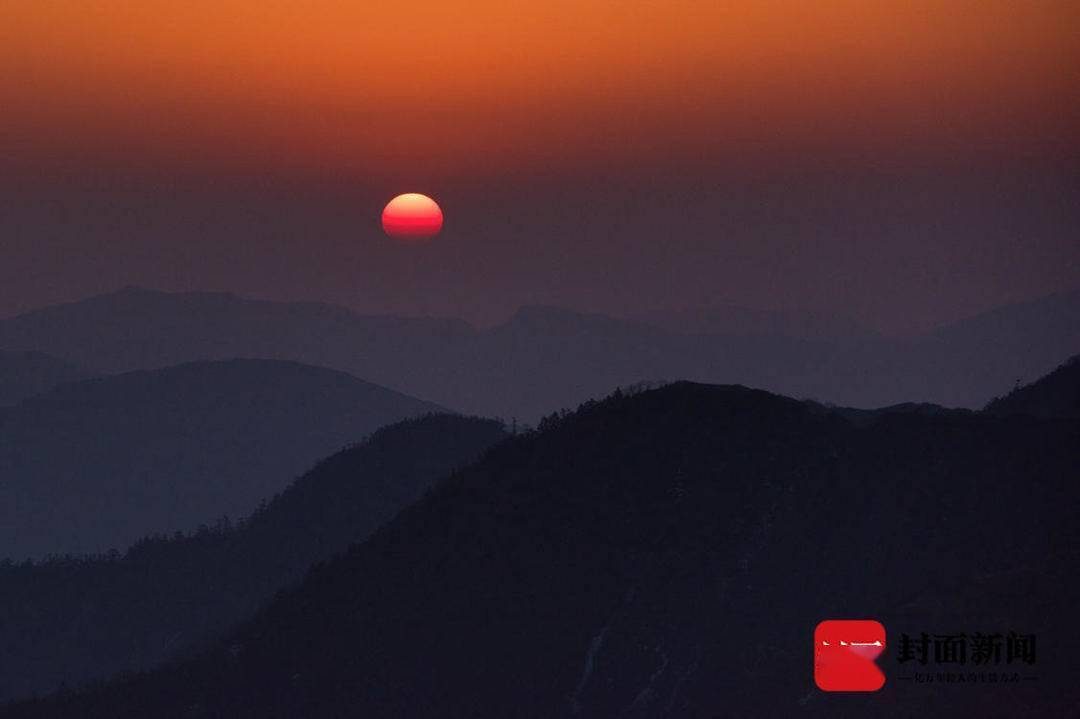 红日初升,群山在朝阳中显出美丽剪影.