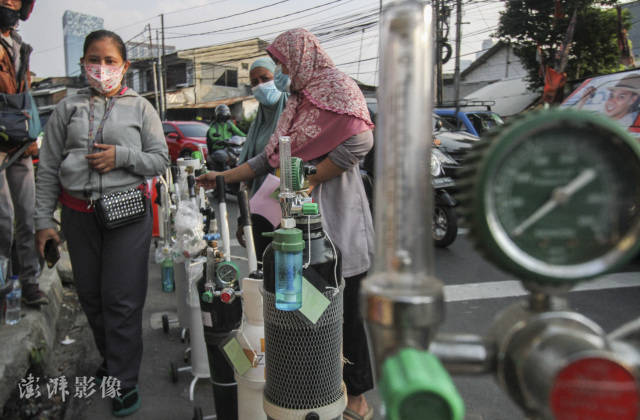 当地时间7月9日,印度尼西亚雅加达一加气站内,人们排队领取氧气装满