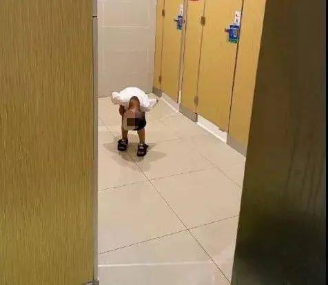 在干嘛?一小男孩在桂林某商场女厕所内,低头往厕所门里看!
