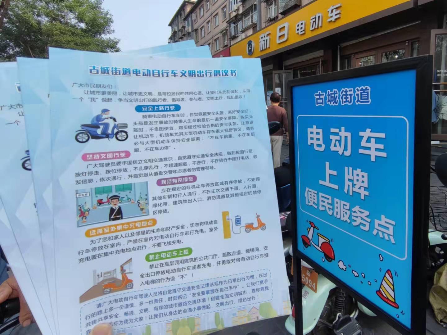 "古城街道电动车上牌便民服务点"指示牌方便了来换购上牌的居民