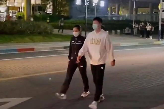 从训练馆出来时,两人几乎并排走着,夜幕下,借着路灯,穿白色与黑色衣服