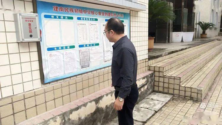 冯校长在查看食堂公示情况.