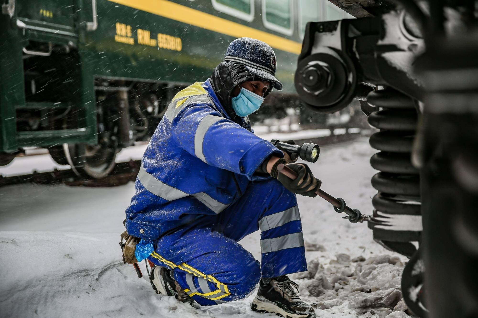 铁路工作人员在雪中检修列车.哈尔滨铁路局 供图