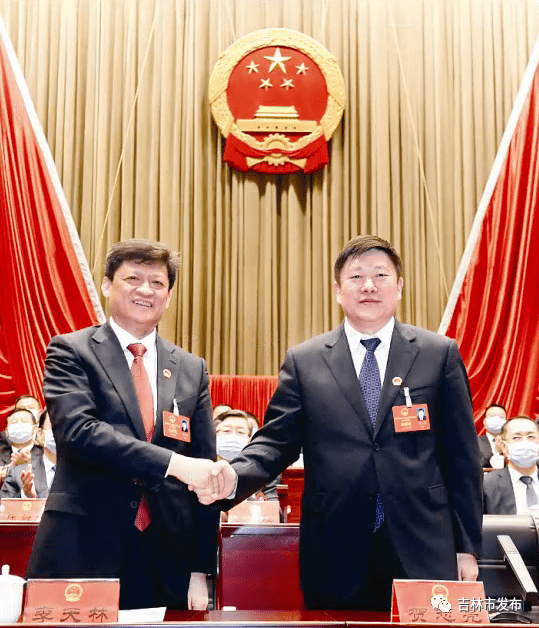 图为市委书记贺志亮(左)与新当选的吉林市人民政府市长王路握手表示