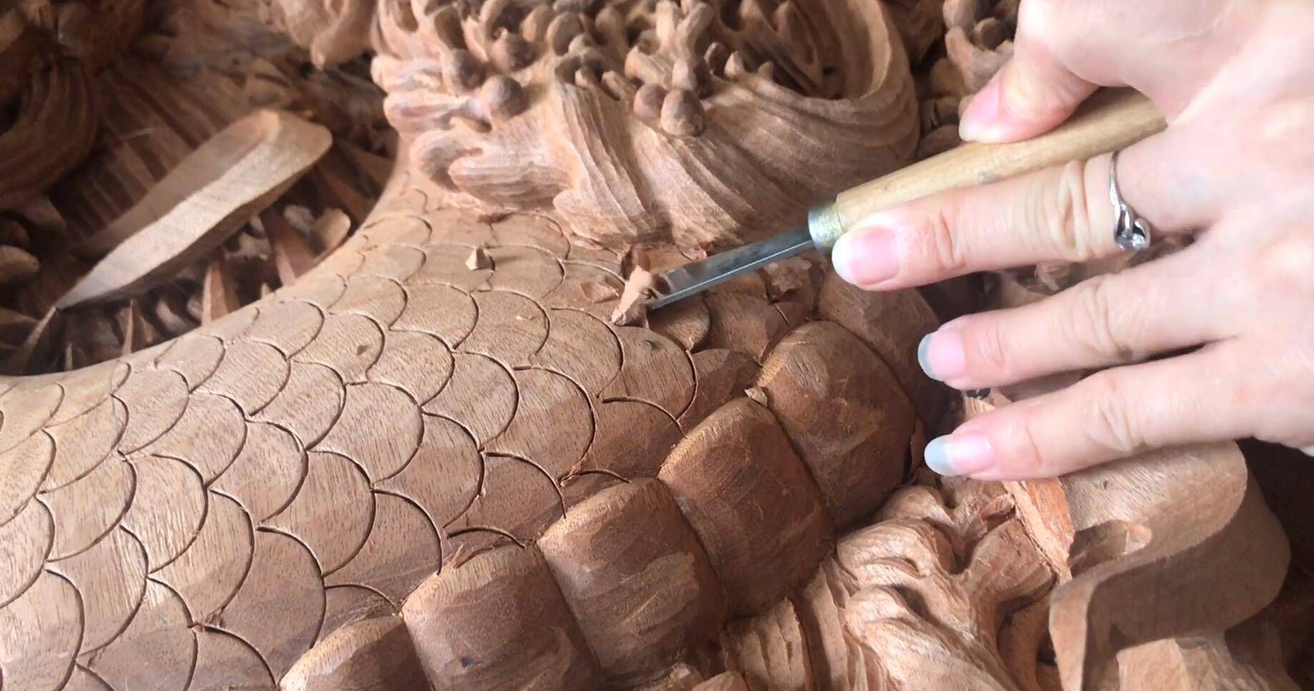 我们看到此时雕刻大师正在雕刻龙鳞,而龙鳞的细节那也是非常的复杂,稍
