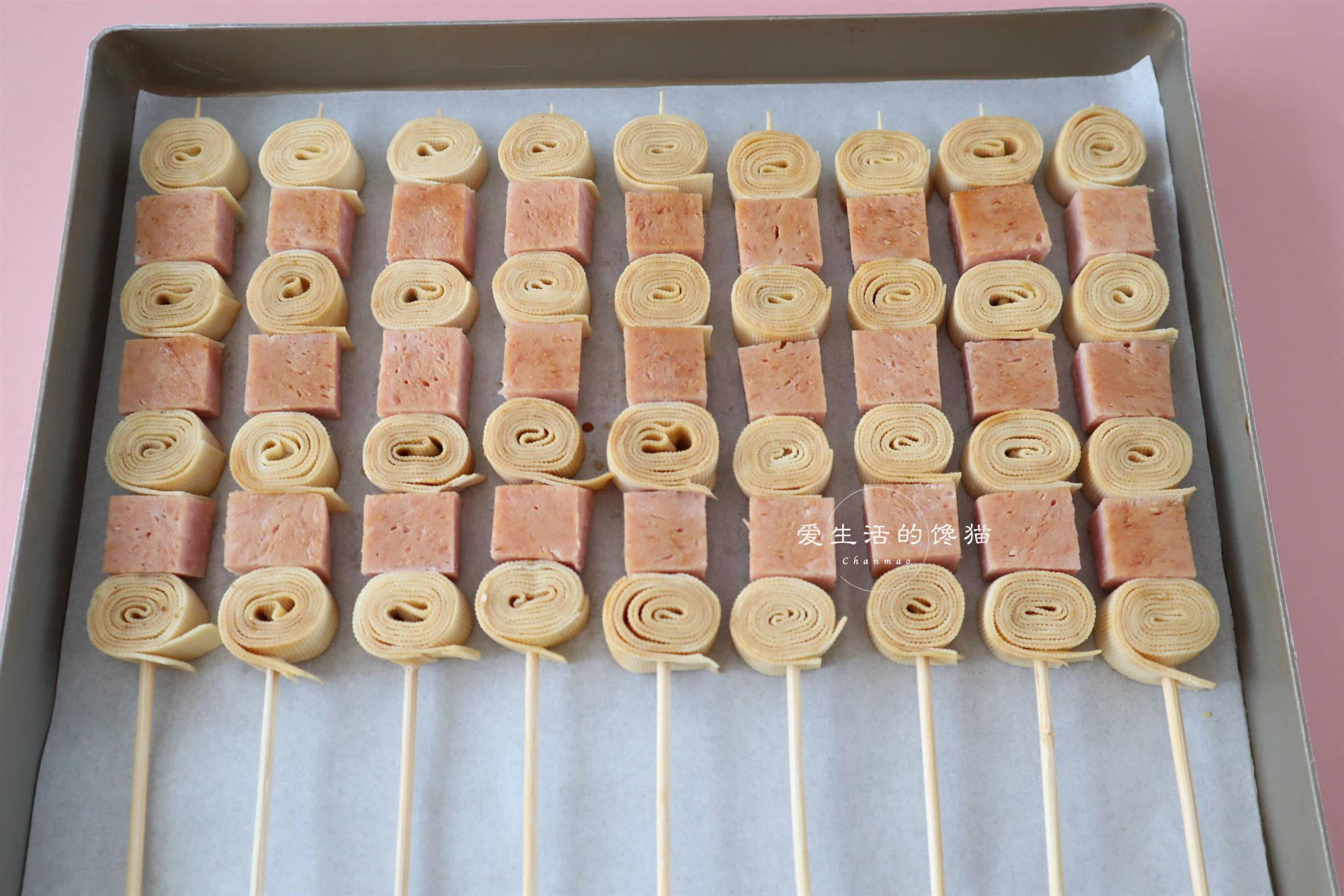 5,接着一个午餐肉粒一个豆皮卷的间隔的串起来,全部都串好.