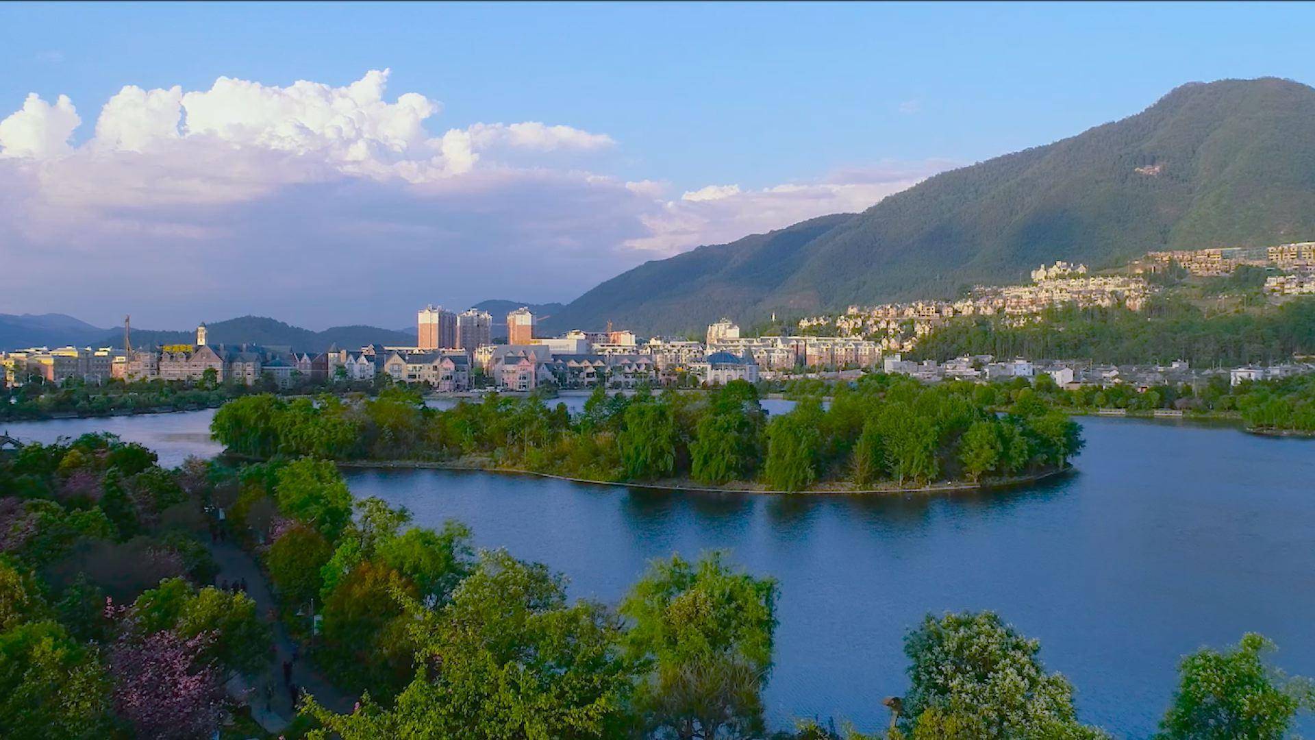 难得的雨后初晴,腾越河两岸,三三两两的人们沿着河堤的步道在散步