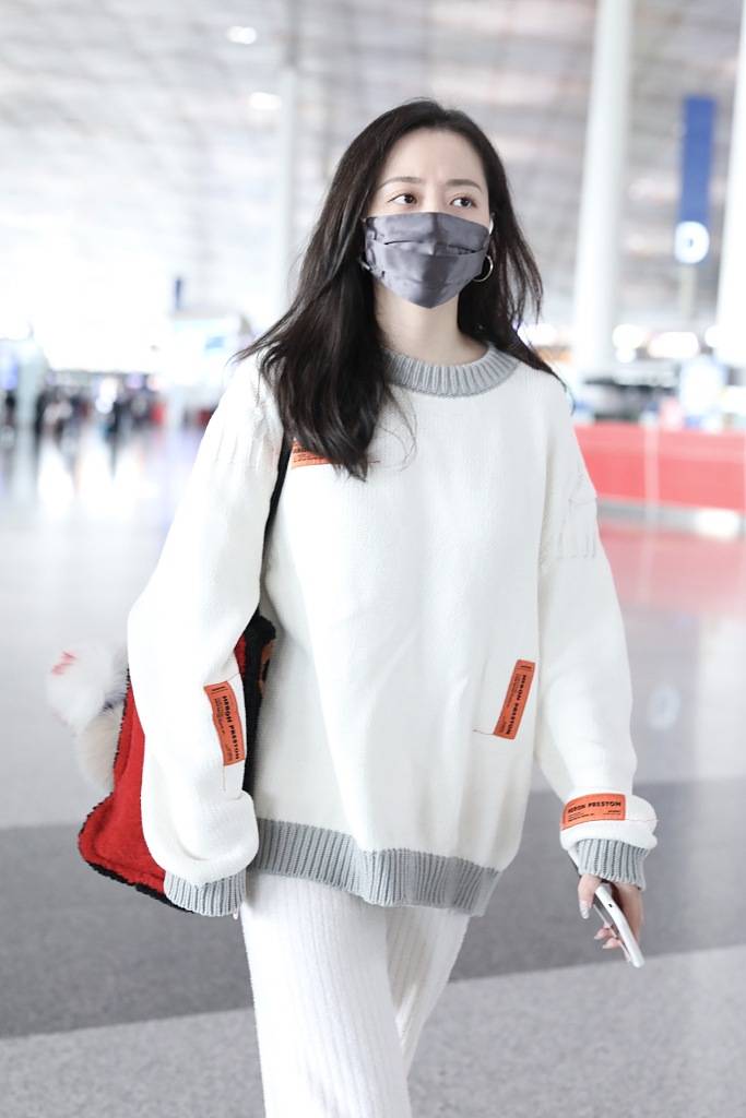 张靓颖穿白衣搭机清丽温婉 男友帮忙拎包推行李