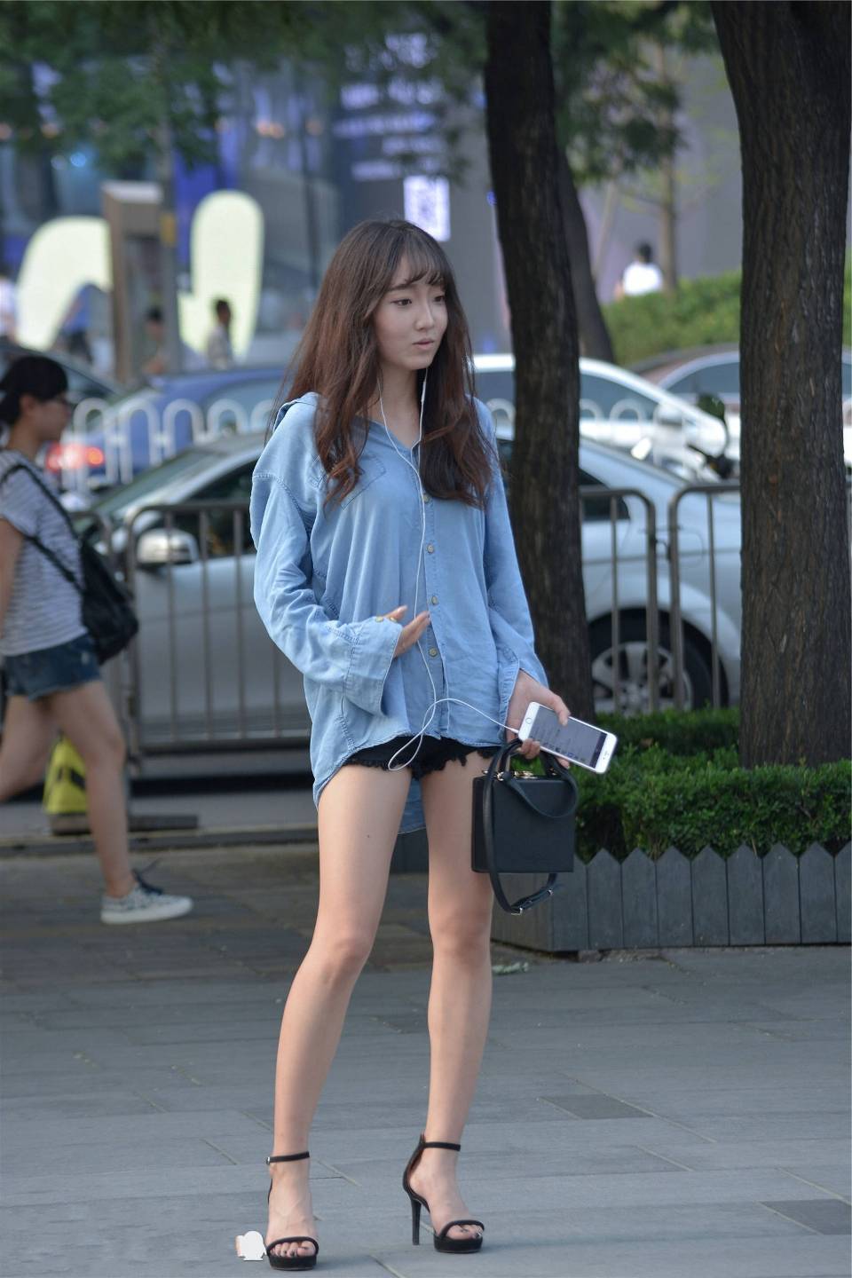 路人街拍美女用蓝色的长款衬衫作为搭配展现好身材