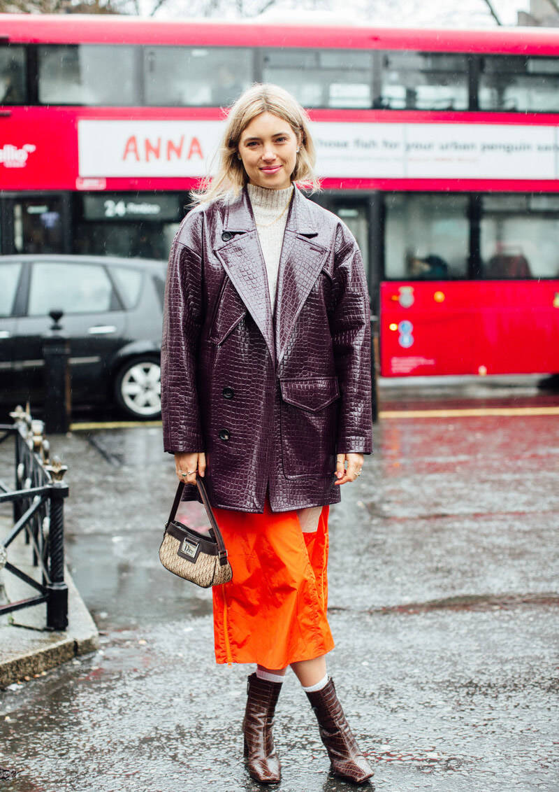 比如穿一件枣红色的中长款皮衣,搭配桔色包臀半身裙,脚上穿双枣红色的