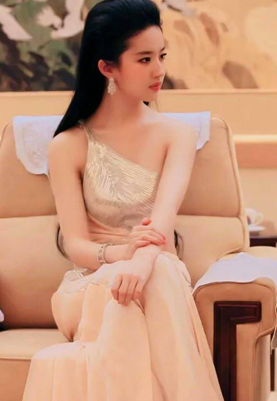 其中单侧吊带的不对称造型个性独特,露肩的设计又彰显出了刘亦菲纤细