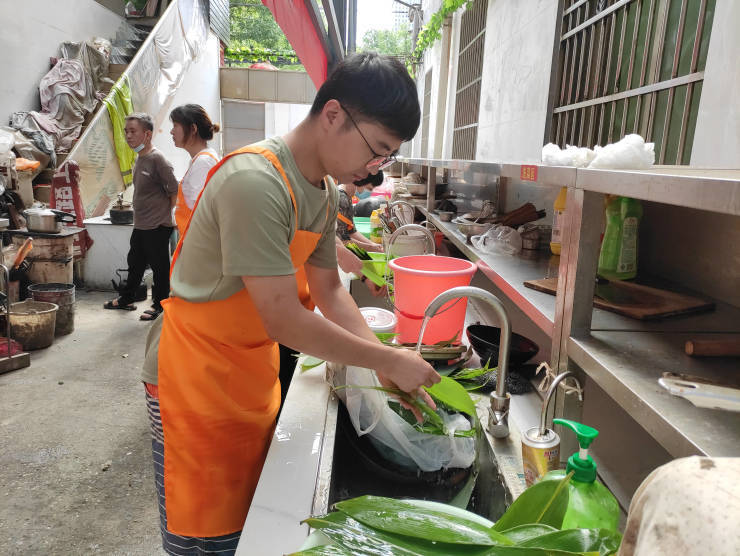 在爱心厨房,邹海云与万佐成夫妇热情交谈,仔细地询问