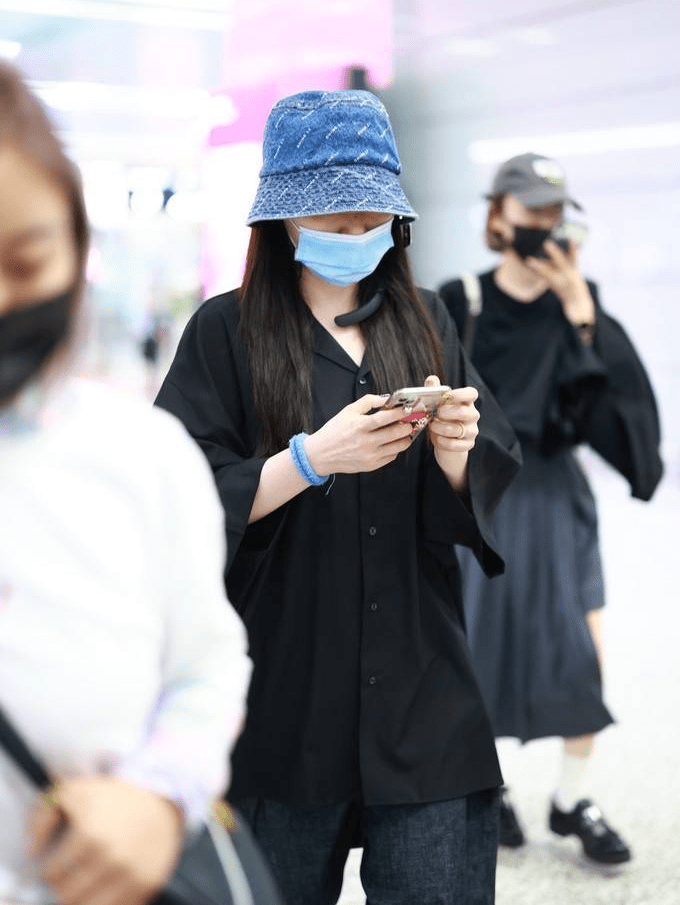 金靖身穿黑色衬衫搭配深蓝色牛仔裤休闲随性