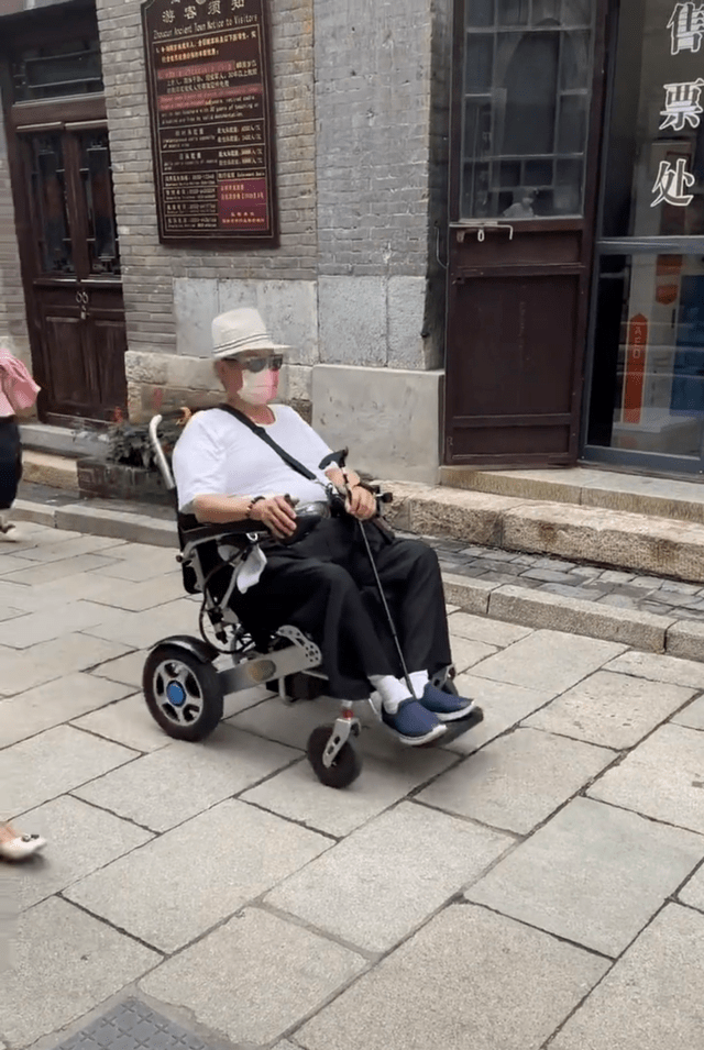 内地|洪金宝罕携妻内地度假，身形暴瘦俩人搀扶走不动，妻子拿手机拍不停