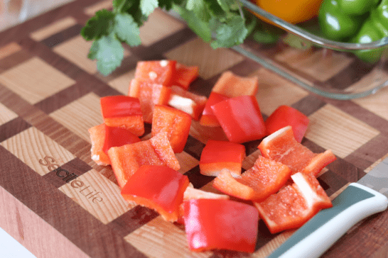 3,下一步接着切彩椒,把所有的彩椒圈切成一个个大小均等的彩椒块,每一