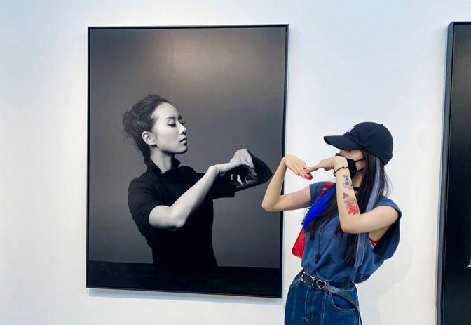 展真|杨幂遛弯看展真悠闲，穿无袖反手大花臂抢镜，见自己海报俏皮合拍