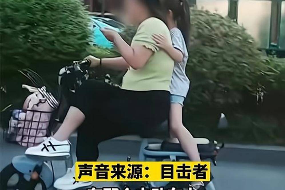 原創山東一女子蹺二郎腿騎車玩手機,女兒站立在車後,簡直是在玩命