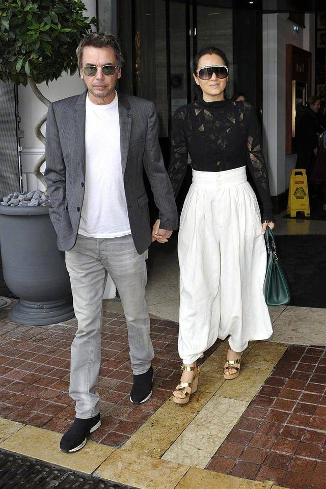 老公|巩俐与老公海边度假,扎丸子头配短裤霸气不再,71岁老公非常时尚