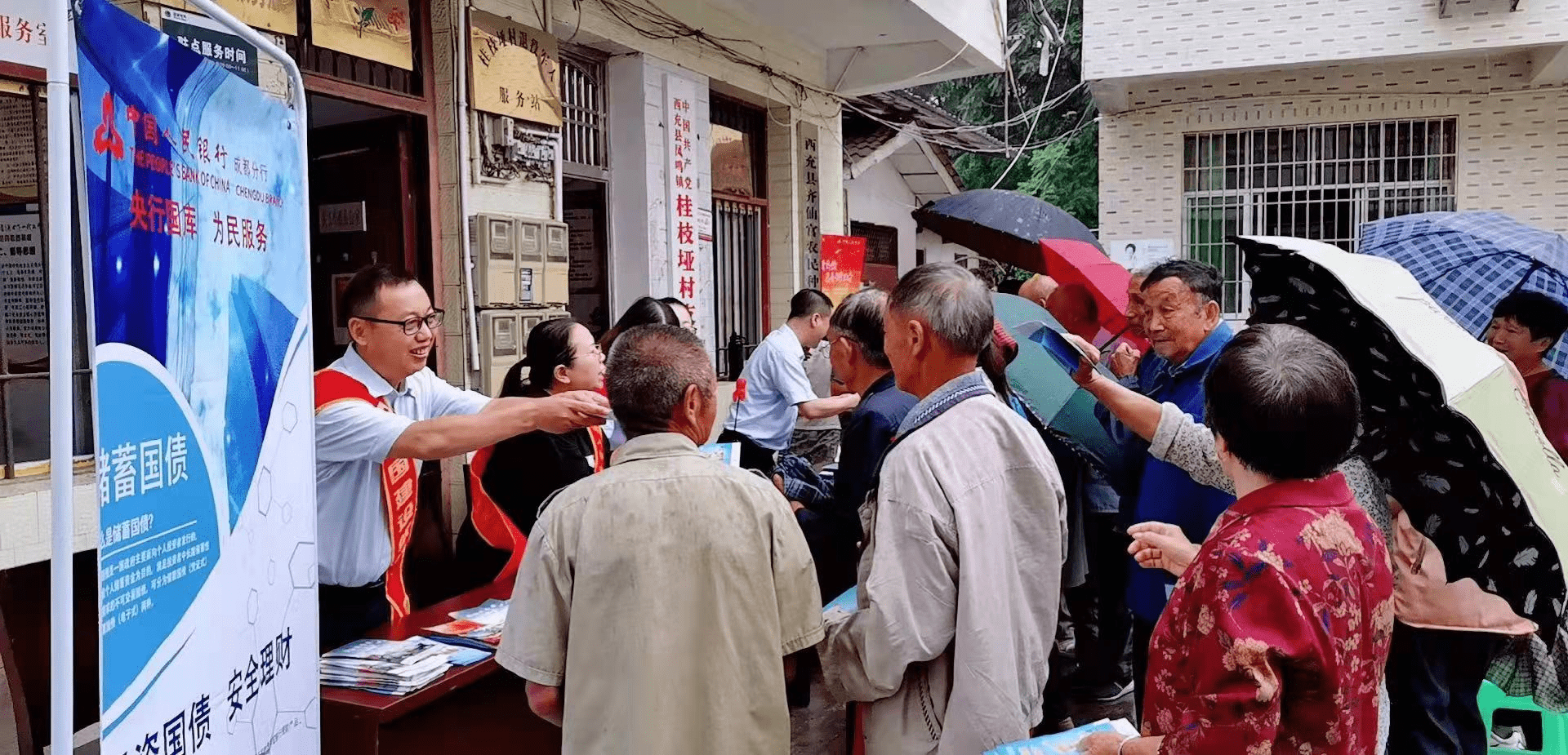 图为建行工作人员向村民宣传国库惠民相关知识