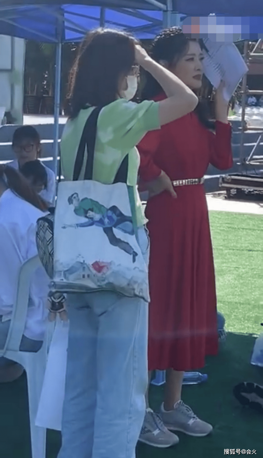 状态央视主持周涛罕化浓妆！穿红礼裙脚踩运动鞋，烈日下叉腰站立满头汗