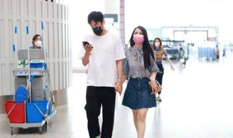 短裙 伊能静跟老公机场甜蜜牵手，穿蝴蝶衬衫配短裙，看着比秦昊还年轻