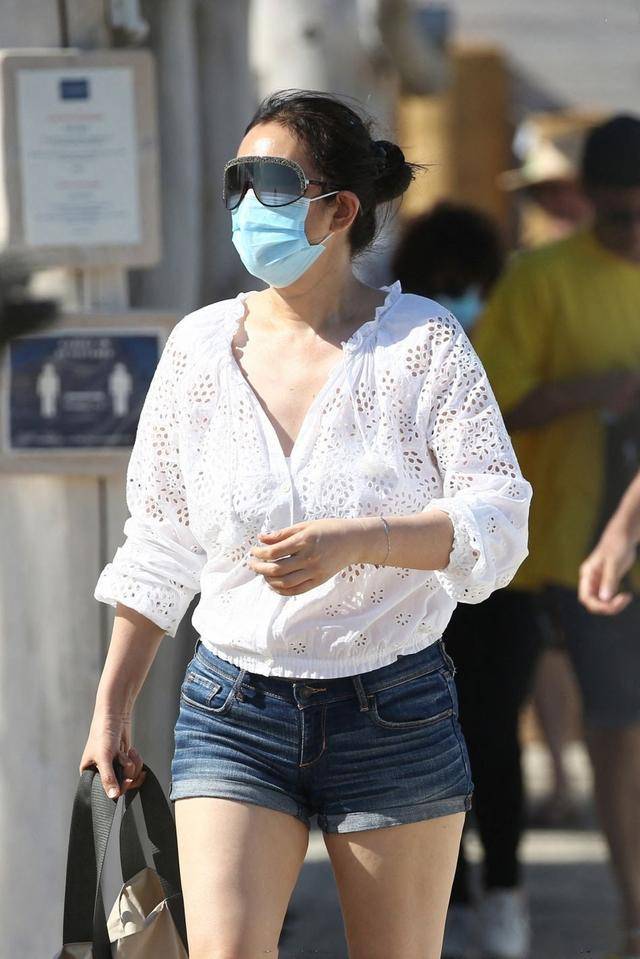 老公 巩俐与老公海边度假，扎丸子头配短裤霸气不再，71岁老公非常时尚