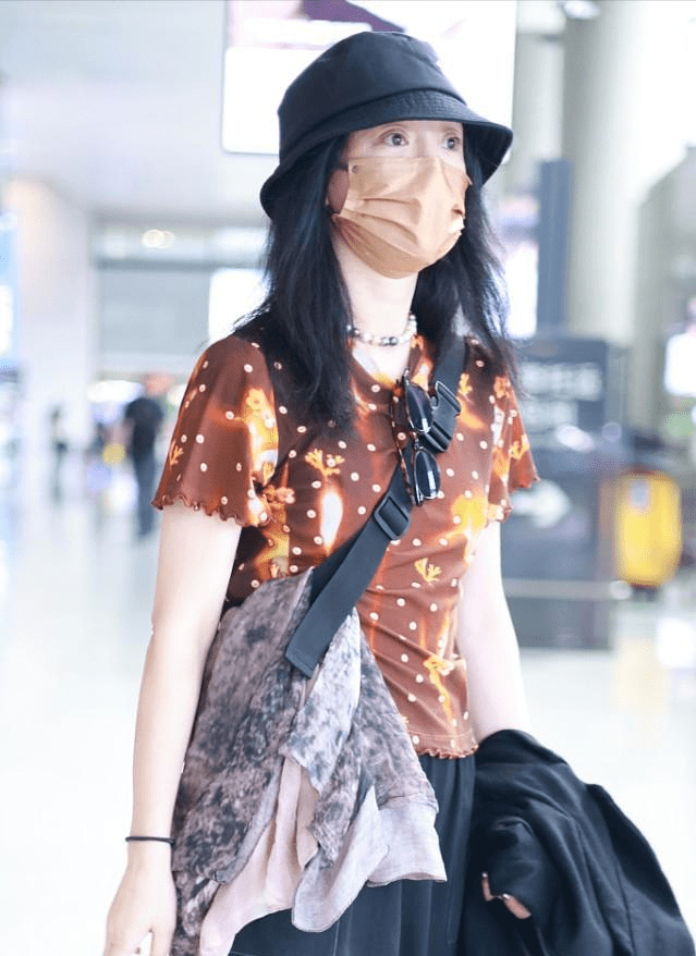 个性 周迅走机场挺“张扬”，穿棕色星空小半袖，脚上穿的粉袜子更抢镜