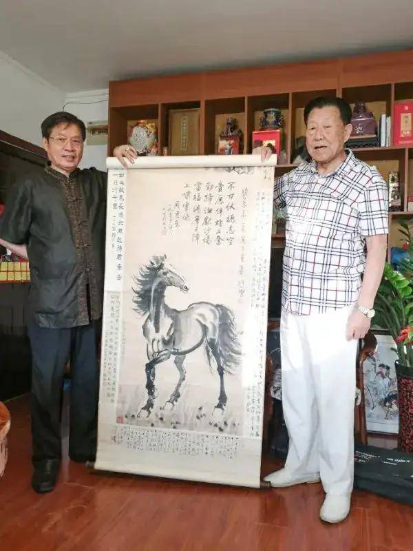 古今明先生(右)赏鉴徐悲鸿《红日松马图》并题评艺术顾问谭勇教授(中)