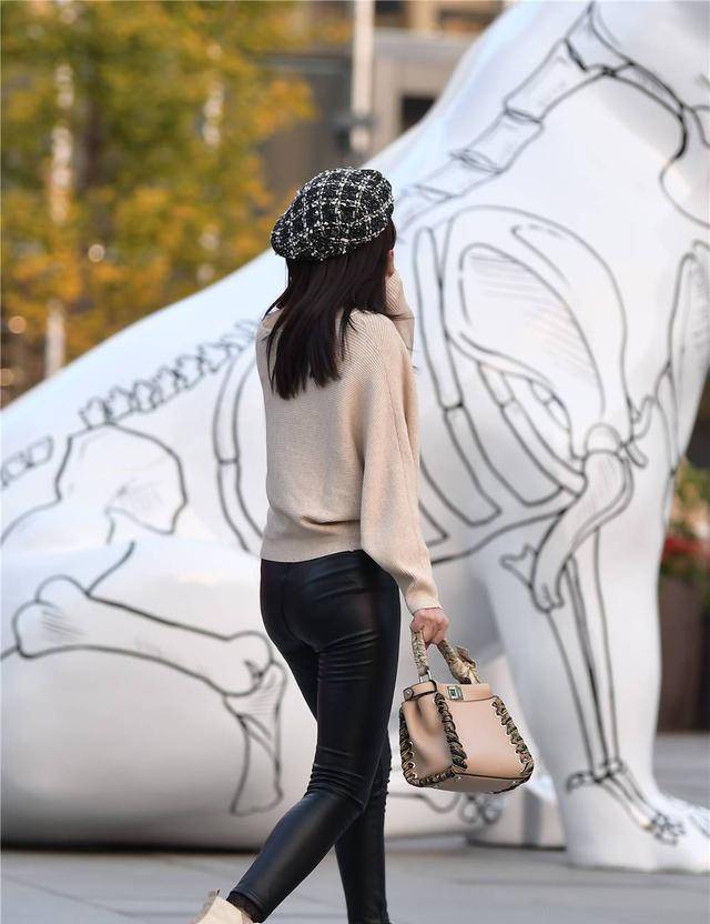 身材 黑色紧身皮裤搭配米色的马丁短靴，有点不一样的味道，衬托身材
