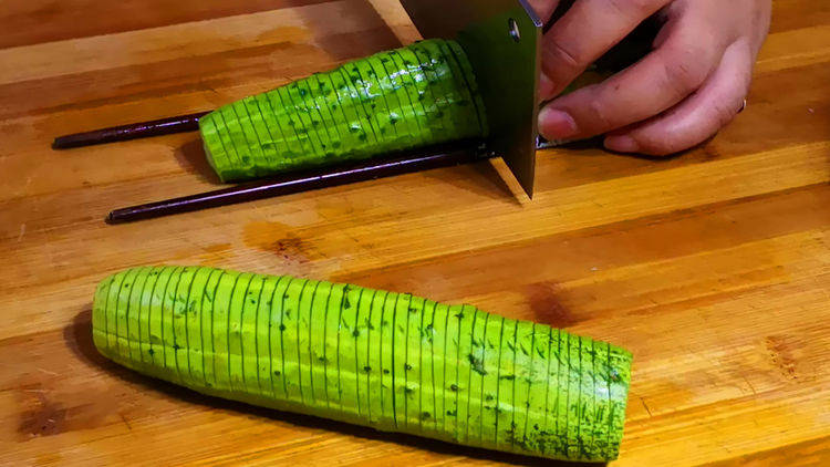 1.黄瓜去掉头尾,用2根筷子夹住横着切花刀,厚度0.