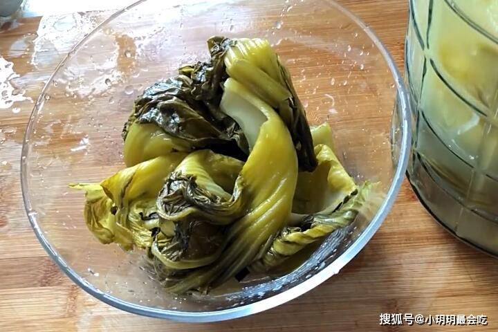 這樣的容易將酸菜醃壞,把燙好的白菜放進去,然後倒入剛才煮好的淘米水