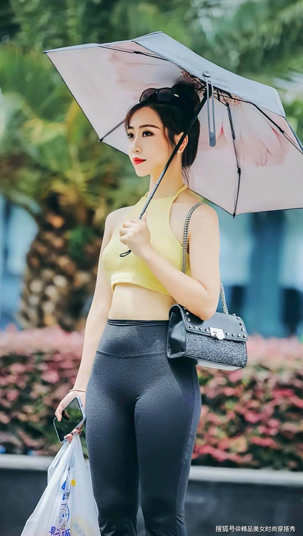 个性 黄色的挂脖背心清凉吸睛,下搭一条黑色的紧身喇叭裤,休闲又性感